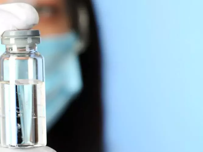 Scientist holding a vaccine vial